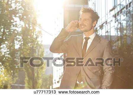 Young businessman using cell phone outdoors View Large Photo Image Stock Image - Young businessman using cell phone outdoors. Fotosearch