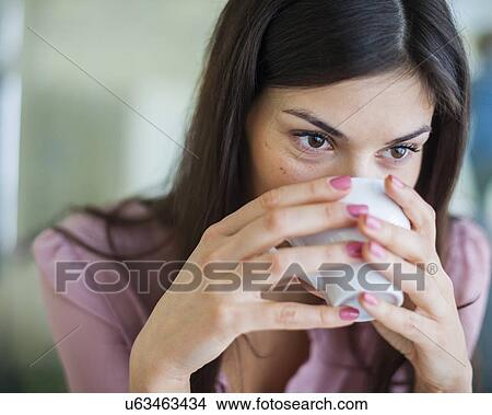 Young businesswoman having coffee in office View Large Photo Image Picture - Young businesswoman having coffee in office. Fotosearch