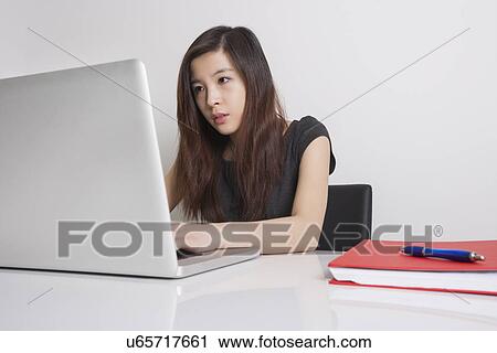 Young businesswoman using laptop in office View Large Photo Image Stock Image - Young businesswoman using laptop in office. Fotosearch