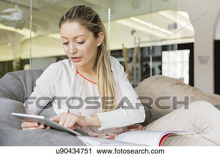 Young businesswoman using tablet PC in office View Large Photo Image Stock Image - Young businesswoman using tablet PC in office. Fotosearch