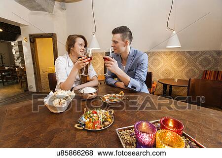 Young couple having wine at restaurant table View Large Photo Image Stock Photo - Young couple having wine at restaurant table. Fotosearch