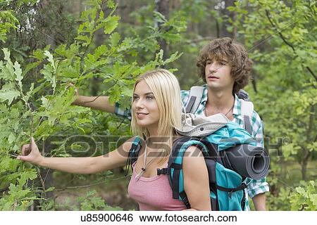Stock Photograph - Young couple hiking in forest. Fotosearch