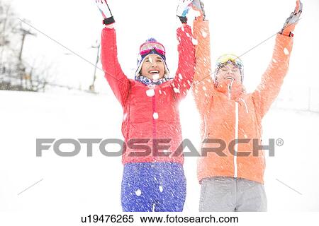 Stock Photography - Young female friends throwing snow. Fotosearch
