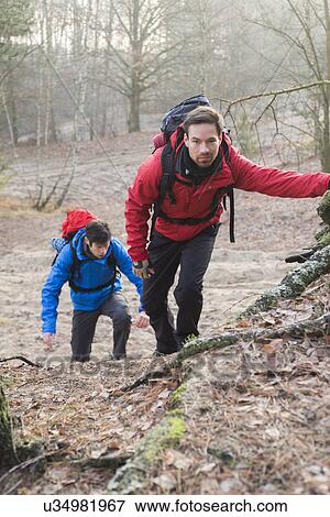 Stock Photo - Young hikers trekking in forest. Fotosearch