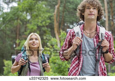 Young hiking couple looking away in forest View Large Photo Image Stock Photography - Young hiking couple looking away in forest. Fotosearch