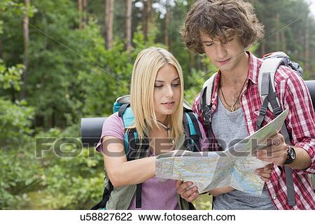 Young hiking couple reading map together in forest View Large Photo Image Stock Image - Young hiking couple reading map together in forest. Fotosearch