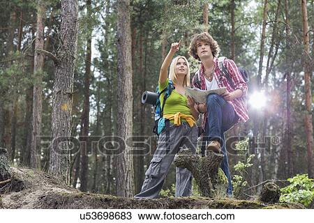 Young hiking couple with map discussing over direction in forest View Large Photo Image Stock Image - Young hiking couple with map discussing over direction in forest. Fotosearch