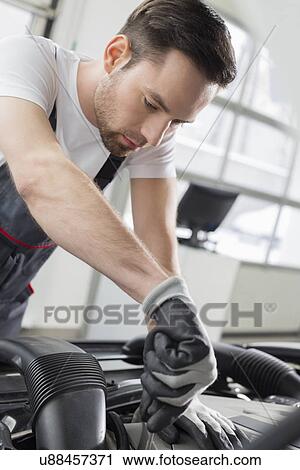 Young maintenance engineer repairing car in automobile store View Large Photo Image Stock Image - Young maintenance engineer repairing car in automobile store. Fotosearch
