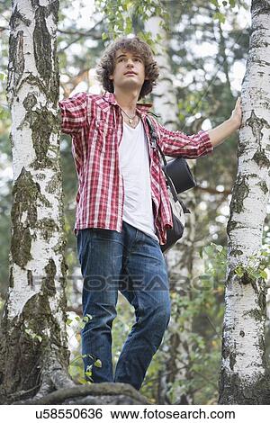 Young male hiker standing in forest View Large Photo Image Stock Photograph - Young male hiker standing in forest. Fotosearch