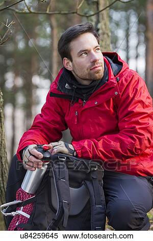 Stock Photography - Young male hiker with backpack in forest. Fotosearch