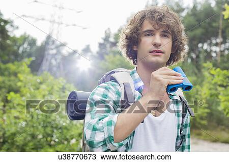Young male hiker with binoculars in forest View Large Photo Image Stock Image - Young male hiker with binoculars in forest. Fotosearch
