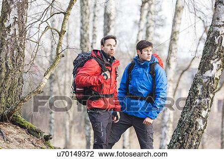 Stock Image - Young male hikers in forest. Fotosearch