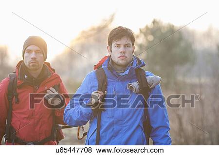 Young male hikers looking away in field View Large Photo Image Stock Photo - Young male hikers looking away in field. Fotosearch