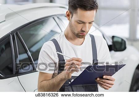 Young male maintenance engineer holding clipboard in repair shop View Large Photo Image Stock Photograph - Young male maintenance engineer holding clipboard in repair shop. Fotosearch