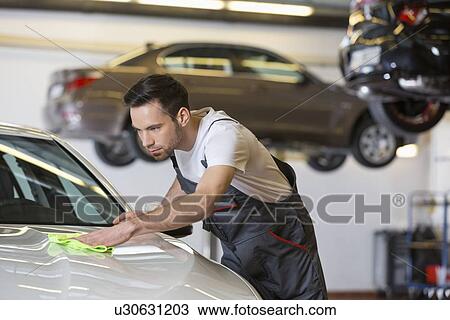 Young male mechanic cleaning car in repair shop View Large Photo Image Stock Image - Young male mechanic cleaning car in repair shop. Fotosearch