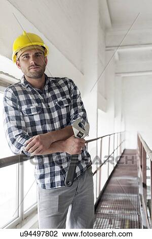 Young male worker with wrench leaning on large industrial valve View Large Photo Image Stock Image - Young male worker with wrench leaning on large industrial valve. Fotosearch