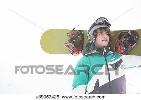 Stock Photography - young man carrying snowboard against clear sky. Fotosearch