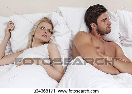 Young man ignoring woman in bed View Large Photo Image Stock Image - Young man ignoring woman in bed. Fotosearch