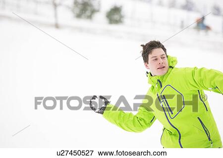 Young man in hooded jacket throwing snowball View Large Photo Image Stock Photo - Young man in hooded jacket throwing snowball. Fotosearch