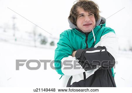Stock Photo - Young man in jacket shivering in snow. Fotosearch