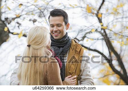 Young man looking at woman in park during autumn View Large Photo Image Stock Photograph - Young man looking at woman in park during autumn. Fotosearch