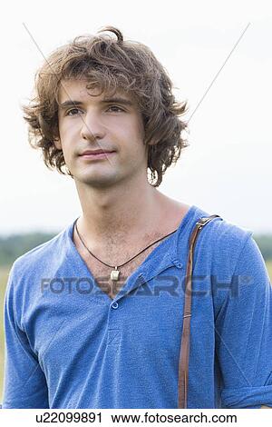 Stock Image - Young man looking away against clear sky. Fotosearch
