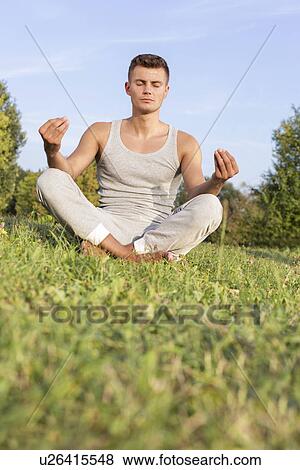 Young man meditating in park View Large Photo Image Stock Photo - Young man meditating in park. Fotosearch