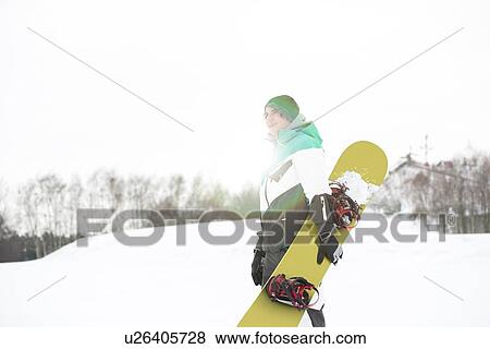 Young man with snowboard walking in snow View Large Photo Image Stock Photo - Young man with snowboard walking in snow. Fotosearch