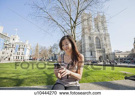 Young woman using cell phone against Westminster Abbey in London, England, UK View Large Photo Image Stock Image - Young woman using cell phone against Westminster Abbey in London, England, UK. Fotosearch
