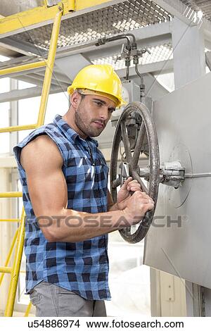 Young worker fixing industrial valve with wrench View Large Photo Image Picture - Young worker fixing industrial valve with wrench. Fotosearch