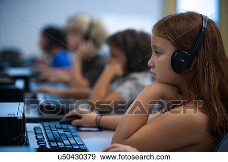 Children using headphones working in the computer lab at Lovett Elementary School in Houston Texas View Large Photo Image Stock Photo - Children using headphones working in the computer lab at Lovett Elementary School in Houston Texas. Fotosearch