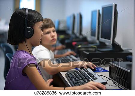 Children using headphones working in the computer lab at Lovett Elementary School in Houston Texas View Large Photo Image Stock Photograph - Children using headphones working in the computer lab at Lovett Elementary School in Houston Texas. Fotosearch