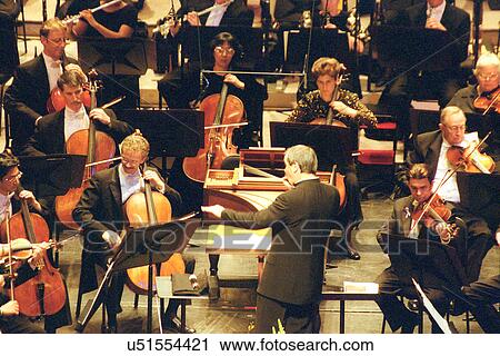 Stock photo of a conductor leading an orchestra View Large Photo Image Stock Image - Stock photo of a conductor leading an orchestra. Fotosearch