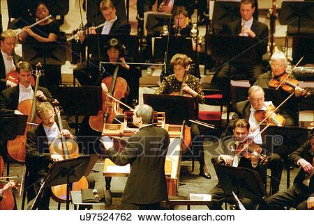Stock photo of a conductor leading an orchestra View Large Photo Image Stock Image - Stock photo of a conductor leading an orchestra. Fotosearch