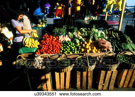 Stock Image - Stock photo of a girl selecting bananas at the farmer's market in Houston Texas. Fotosearch