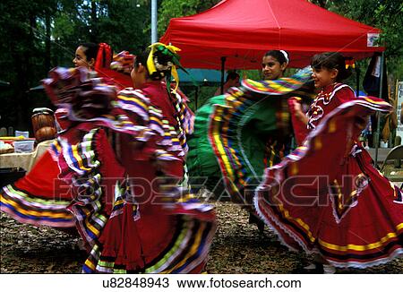 Stock Image - Stock photo of a group of young girls in traditional dresses dancing at a Cinco De Mayo Celebration. Fotosearch