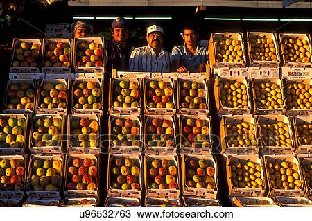 Stock Image - Stock photo of four men from the farmer's market in Houston Texas standing behind crates of fruit. Fotosearch