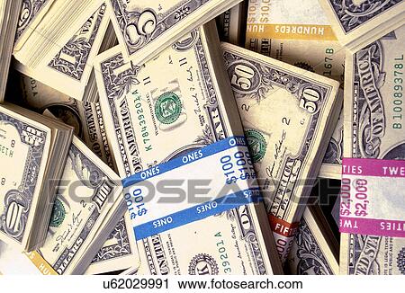 Stock Image - Stock photo of piles of paper currency in different denominations.. Fotosearch