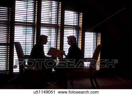 Stock photo of the silhouette of two business associates sitting together in front of a window in an office building View Large Photo Image Stock Image - Stock photo of the silhouette of two business associates sitting together in front of a window in an office building. Fotosearch