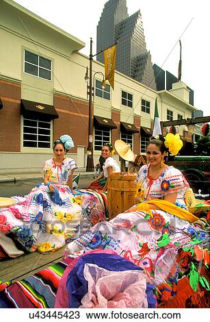 Stock Image - Stock photo of women in typical Mexican costumes sitting on parade float during the Cinco de Mayo parade in downtown Houston Texas. Fotosearch
