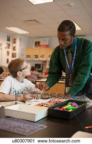 Student receiving help from his art teacher at Lovett Elementary in Houston Texas View Large Photo Image Stock Image - Student receiving help from his art teacher at Lovett Elementary in Houston Texas. Fotosearch