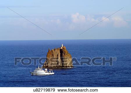 Boat by a rock formation View Large Photo Image Stock Photo - Boat by a rock formation. Fotosearch