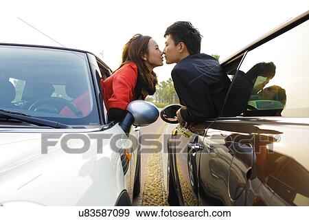 Couple kissing from cars View Large Photo Image Stock Photo - Couple kissing from cars . Fotosearch