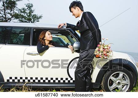 Giving flowers to a woman in a car  View Large Photo Image Stock Image - Giving flowers to a woman in a car . Fotosearch