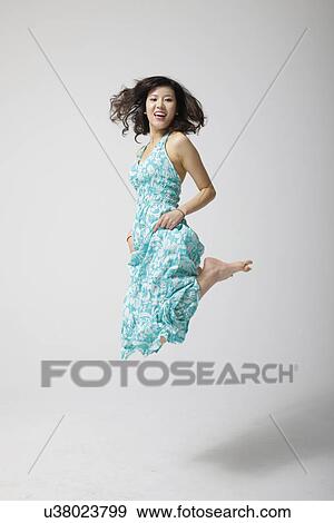 Jumping for joy in a dress View Large Photo Image Stock Photo - Jumping for joy in a dress . Fotosearch
