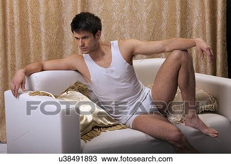 Man sitting on a couch View Large Photo Image Stock Image - Man sitting on a couch. Fotosearch
