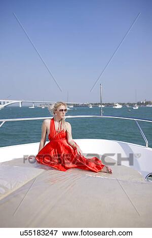 Stock Photo - Sitting on a yacht in a formal dress . Fotosearch
