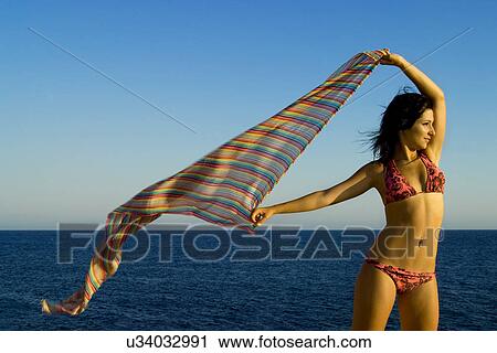 Woman holding fabric in the wind View Large Photo Image Stock Image - Woman holding fabric in the wind . Fotosearch