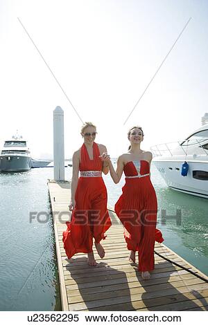 Stock Photography - Woman in formal dresses on a pier . Fotosearch