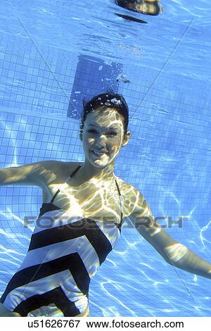 Stock Photo - Woman swimming underwater. Fotosearch
